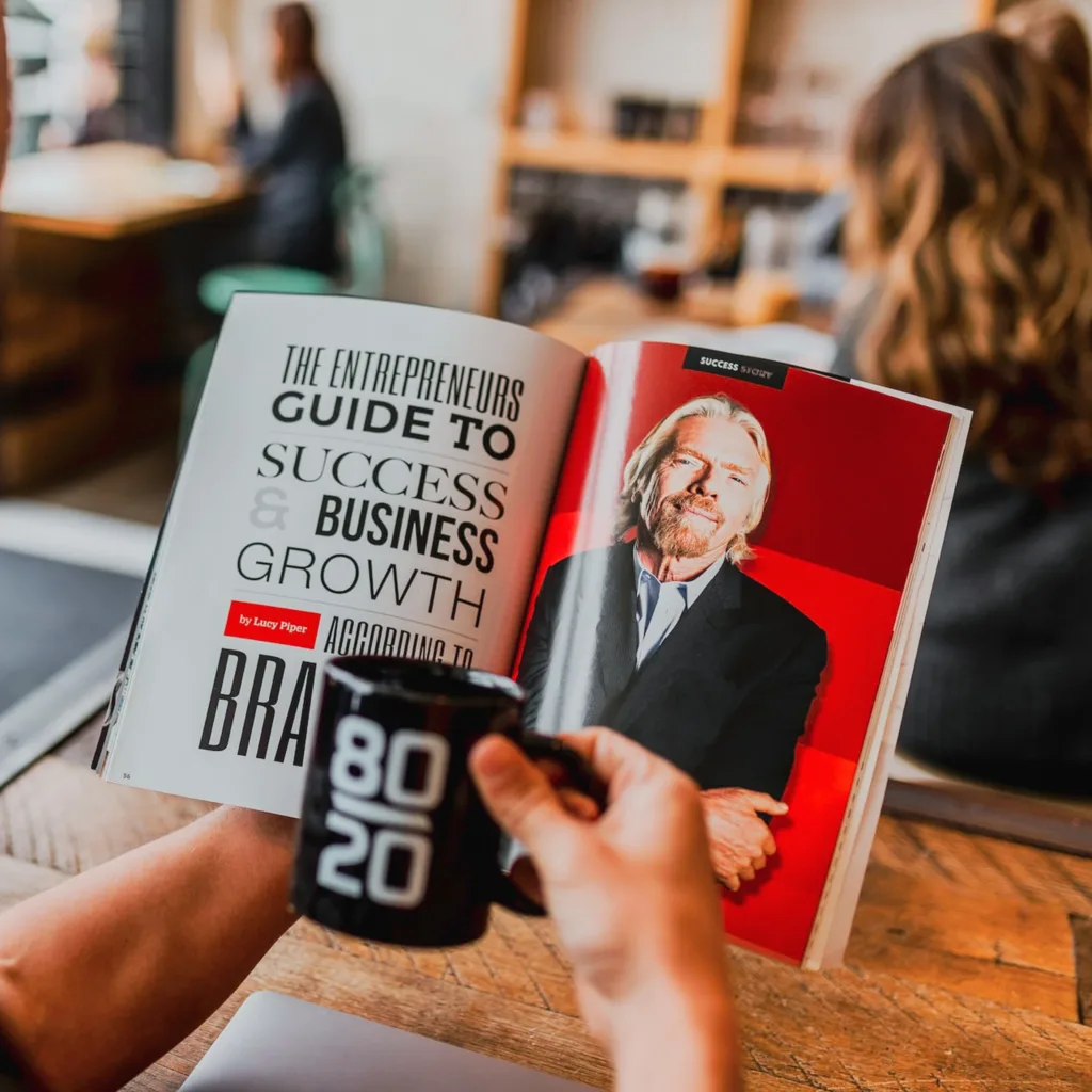 Guide to achieving digital marketing efficiency using the 80/20 rule, represented by a mug and an entrepreneurial success book featuring Richard Branson.