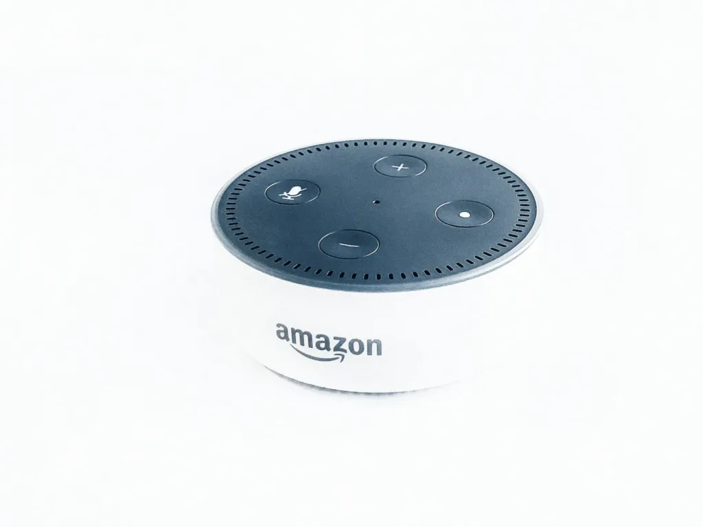 Alexa, the voice-controlled smart assistant, sits on a white desk, displaying the rise of voice search and its implications for SEO. The device's circular blue light glows as Alexa responds to a user's question, highlighting the importance of staying ahead of the game with innovative technology and digital marketing strategies.