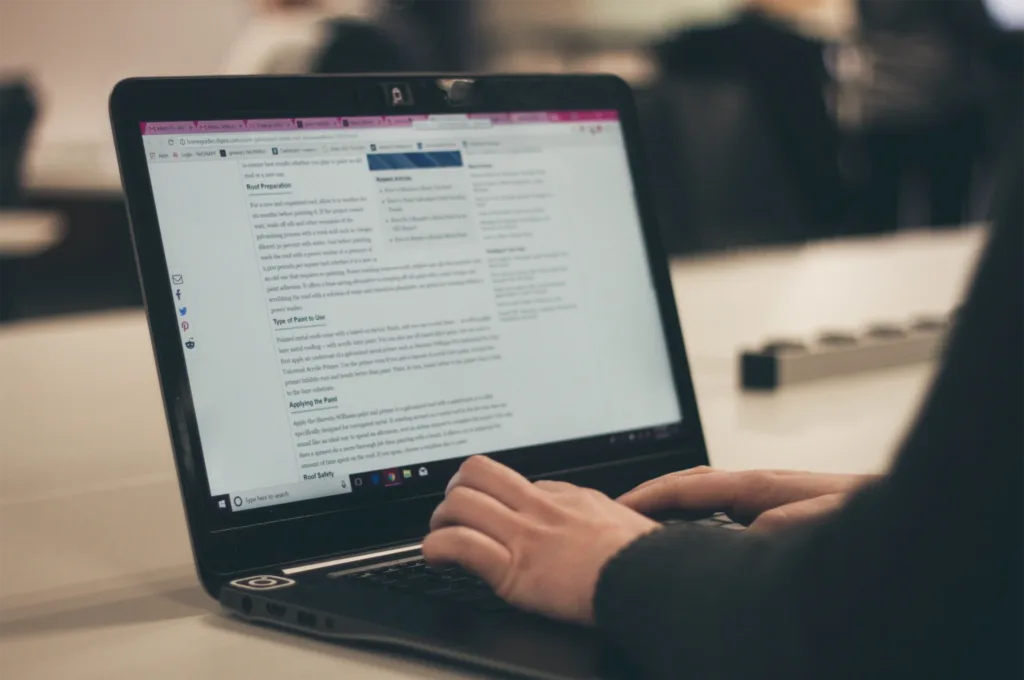 Image of a focused individual typing on a laptop, composing content for their blog.