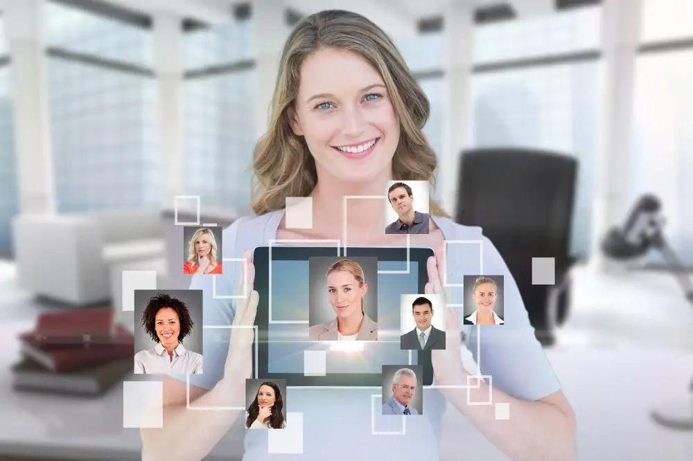 Woman holding a tablet with connected profile pictures representing a virtual network of professionals.