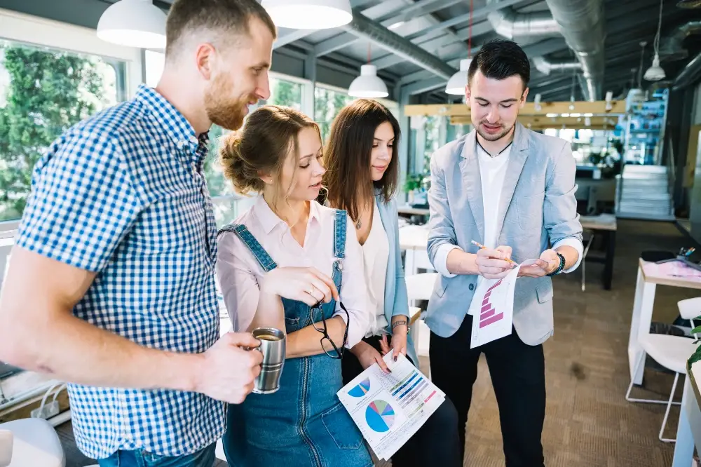 A group of marketers analyzing consumer behavior data with charts and graphs in a modern office setting.